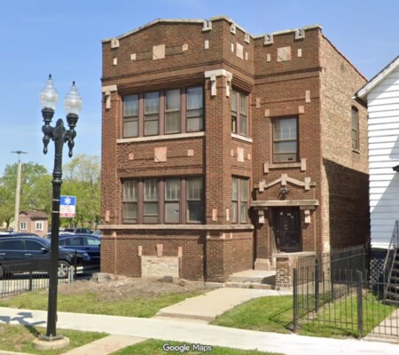 32 W. 111th Street, c.1915, Roseland. A two-story brick two-flat with a corbelled and stepped parapet, projecting bay, stone accent panels and a carved stone entry hood. Demolished August 2026. Photo credit: Google Maps